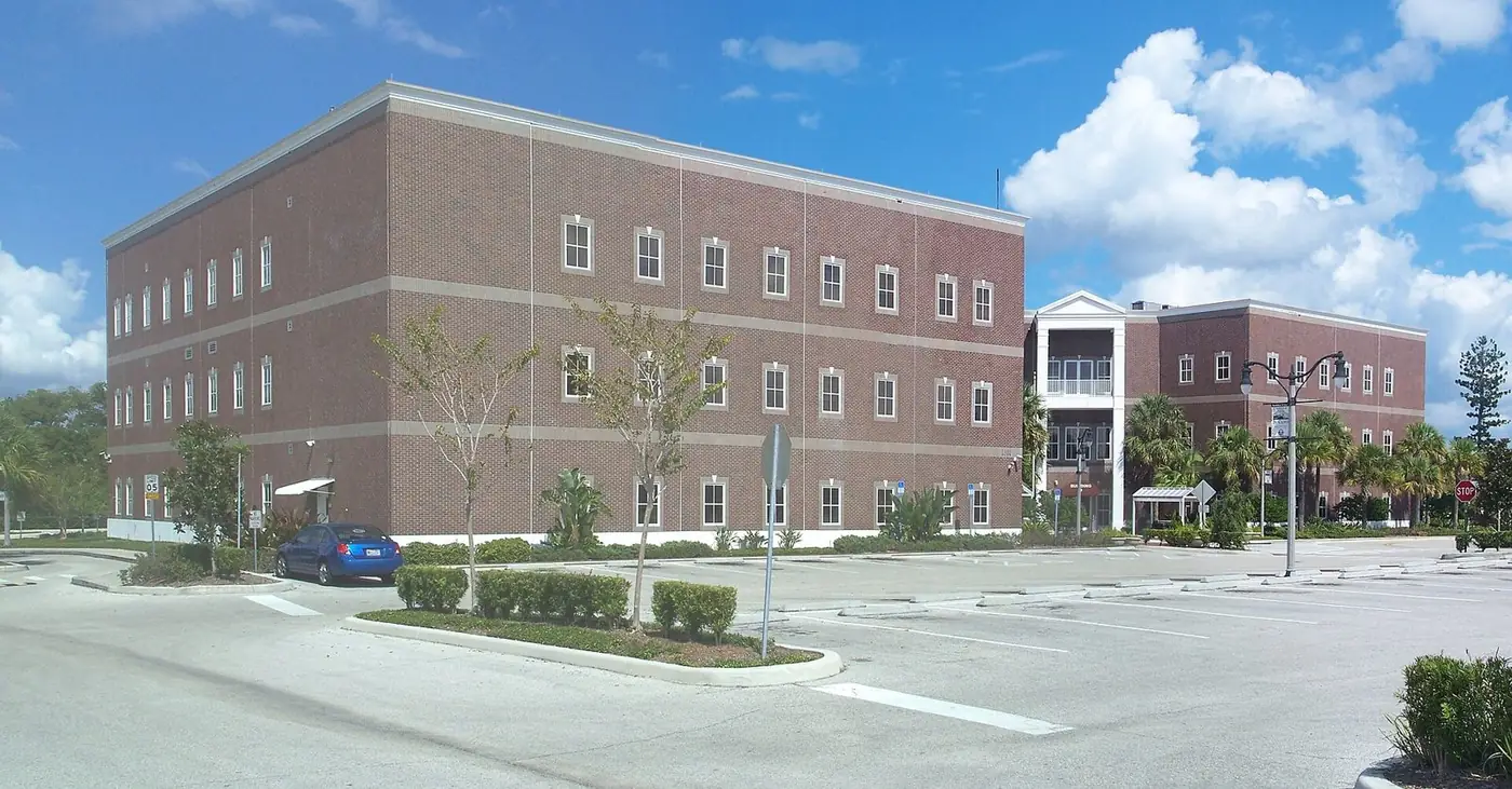 Brick St. Cloud City Hall building with a parking lot in front